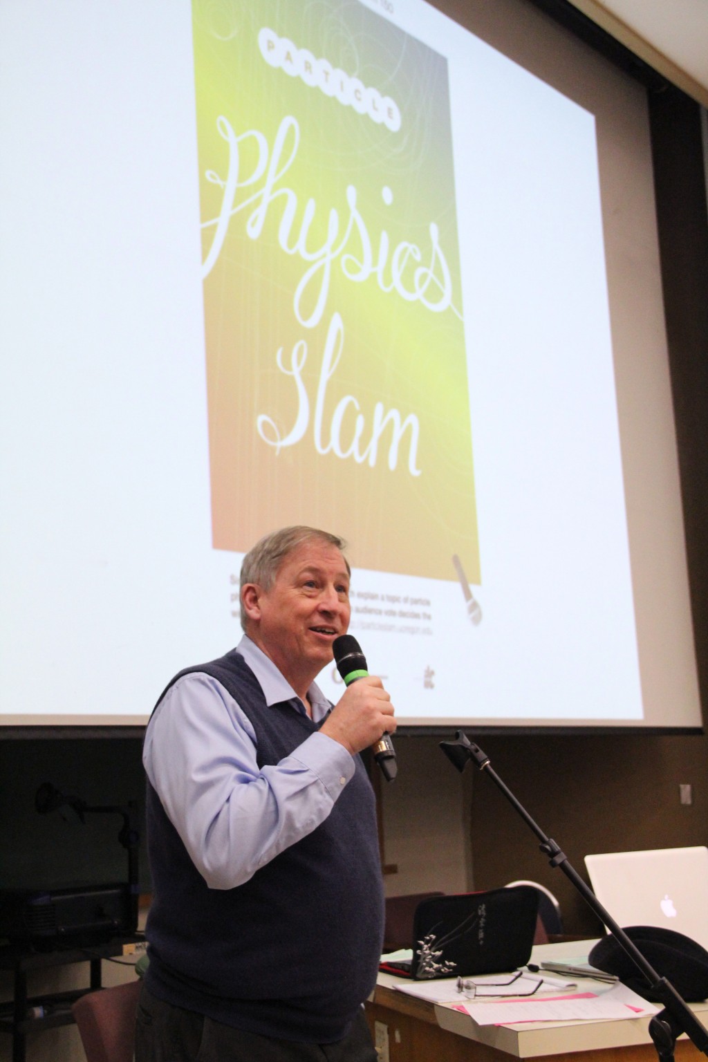 Jim Brau emcees the particle physics slam.  Brau is the ILC regional detector contact for the Americas and professor of physics at the University of Oregon. Image: Jack Liu.